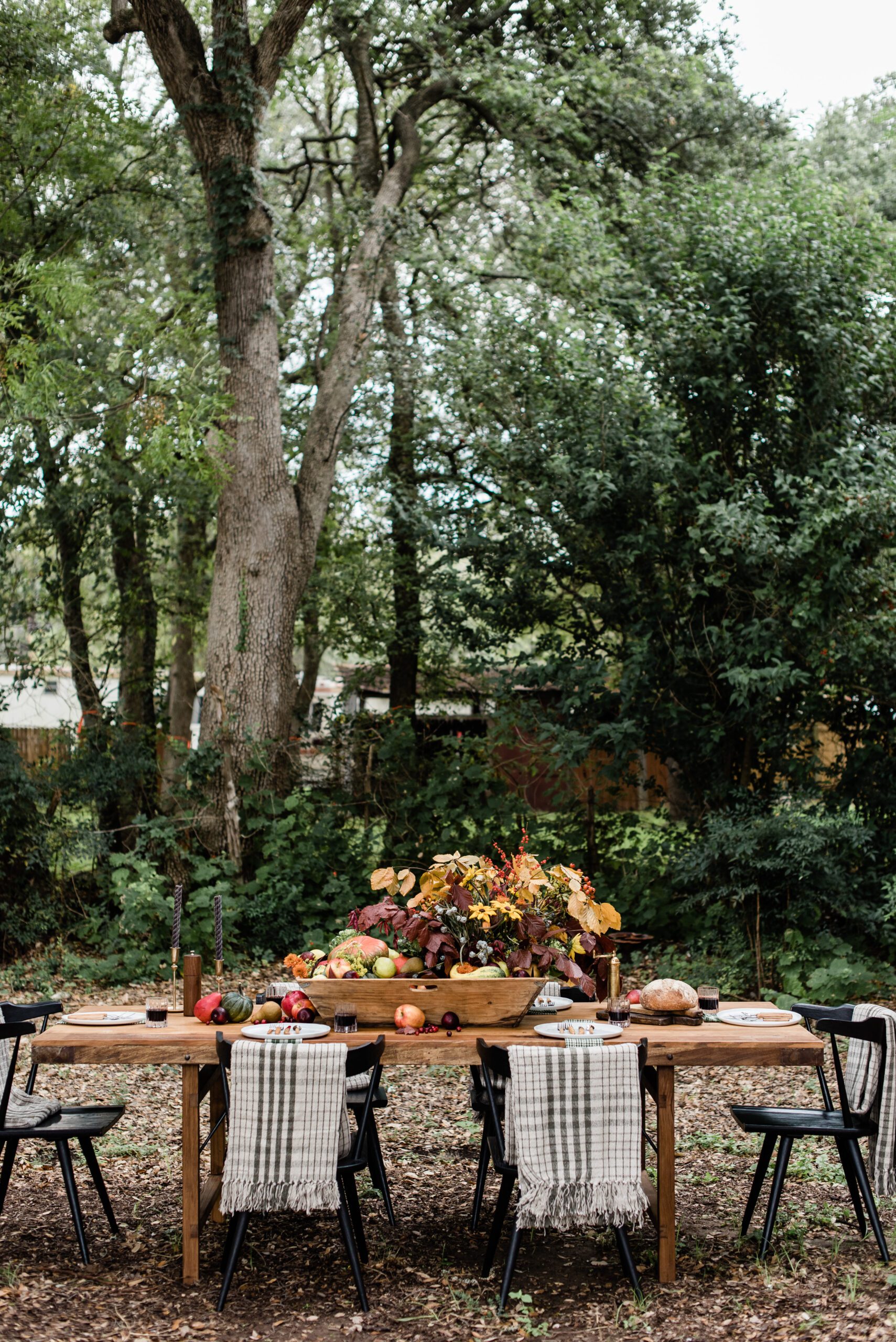 autumn harvest table decor with plaid blankets draped over each seat