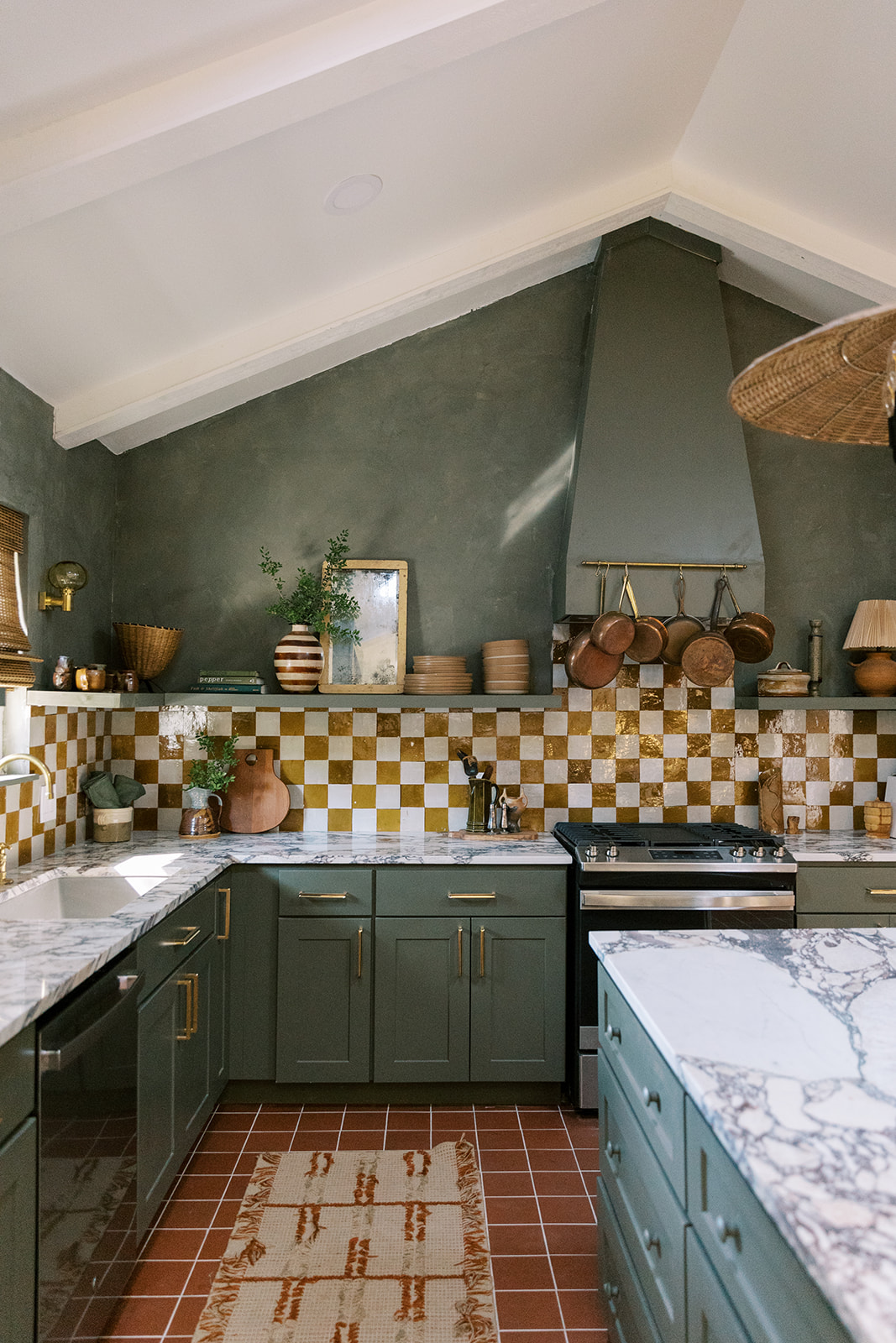 a mid-century designer kitchen with green cabinets and checkerboard backsplash