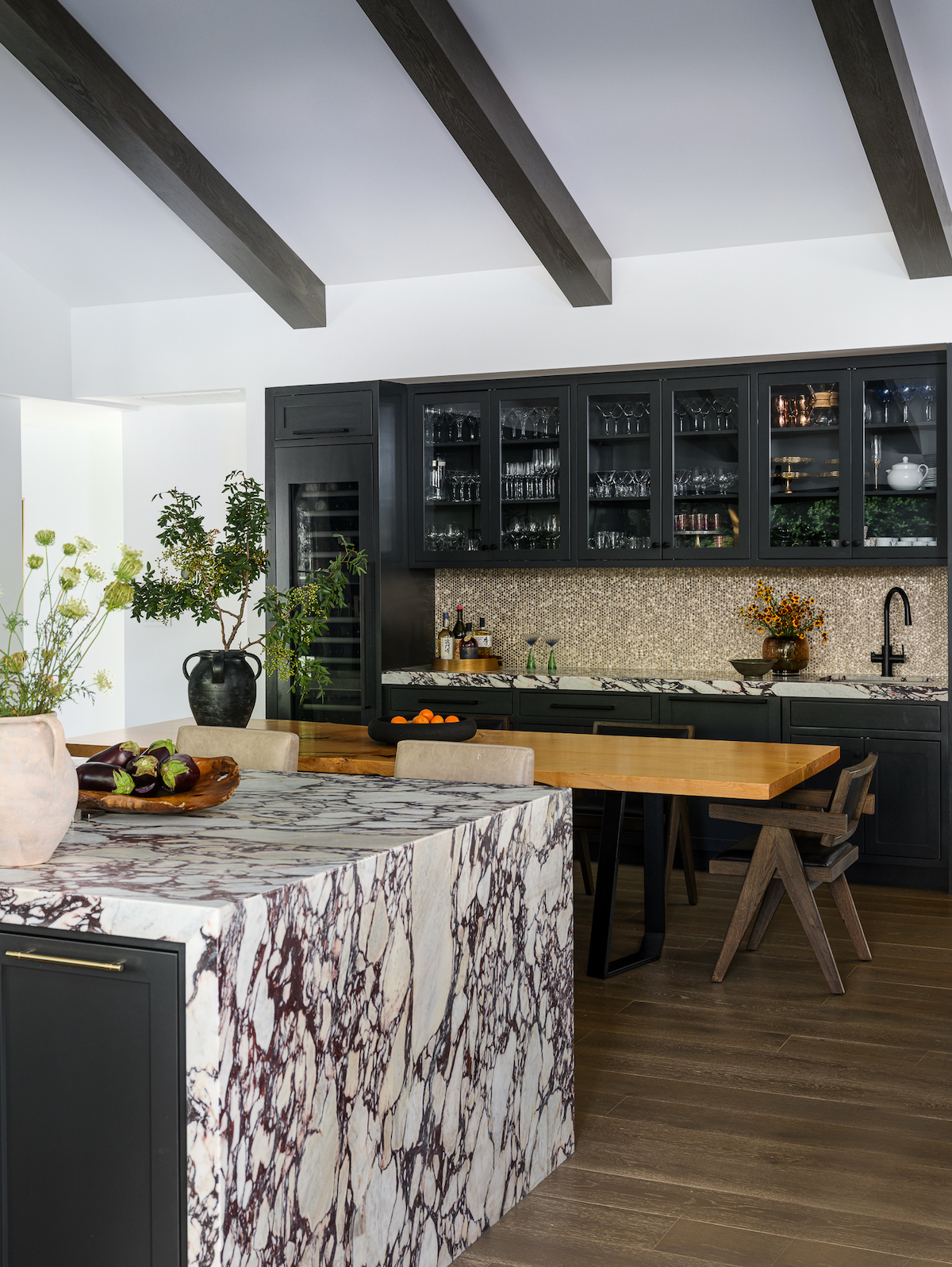 black kitchen cabinets white walls with dark beams on vaulted ceiling