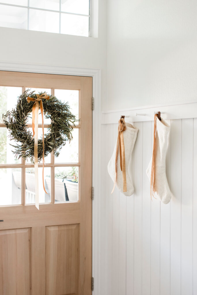 olive leaf wreath and copper velvet ribbon holiday decor in the entryway