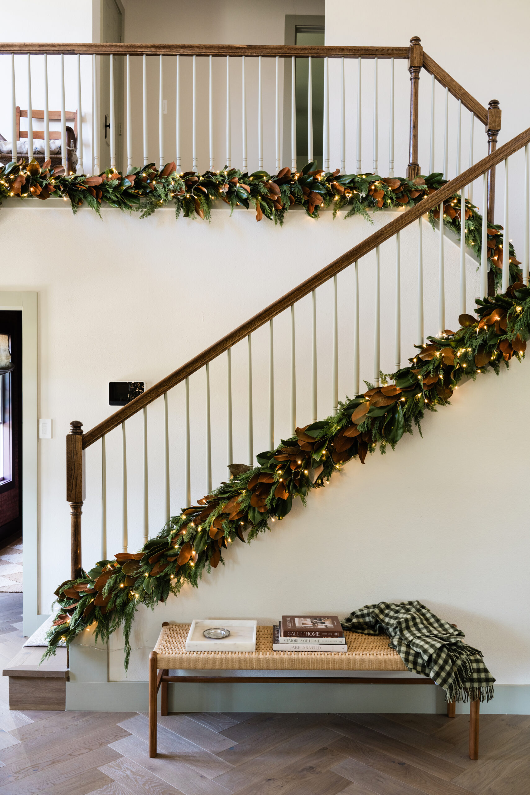 magnolia leaf garland running up the stairs entryway holiday decor