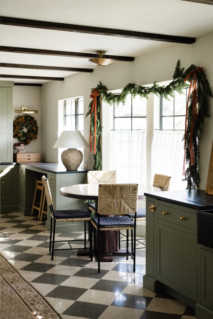 sage green kitchen cabinetry with checkerboard tile and cypress garland with terra cotta velvet ribbon decor in the kitchen