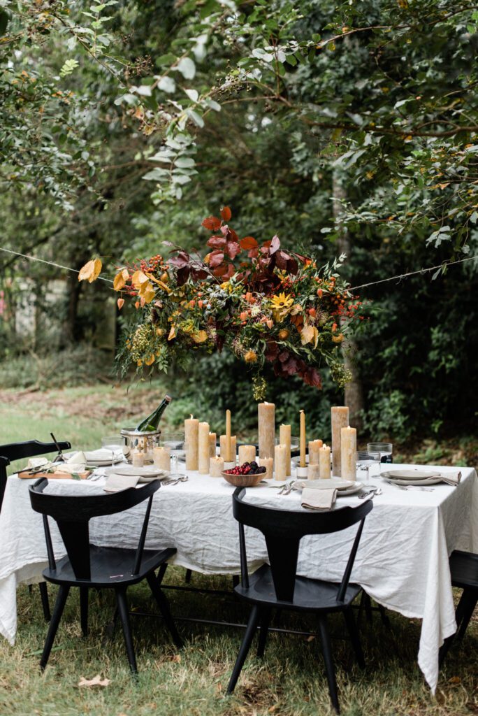 outdoor Thanksgiving table design with suspended autumnal florals