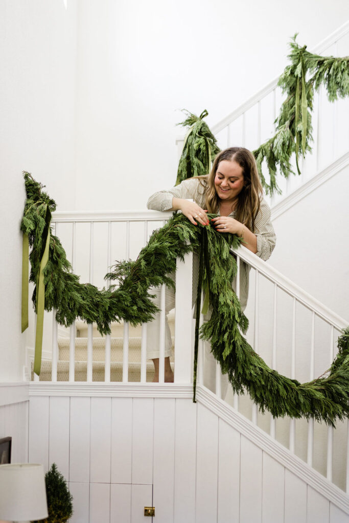 Fresh cypress garland with green ribbons, holiday home decor