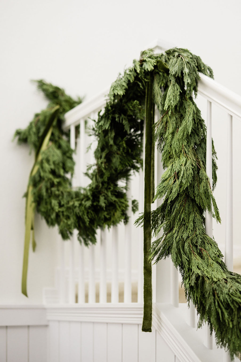 Classic green holiday decorating with cypress garland with green ribbons