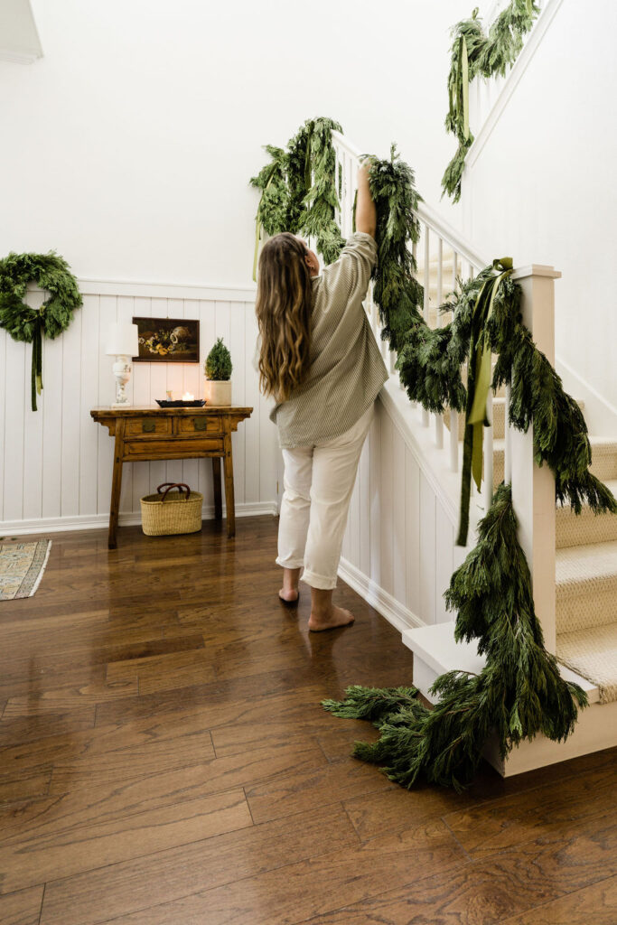 Fresh cedar garlands with ribbon on banisters for holiday decorating
