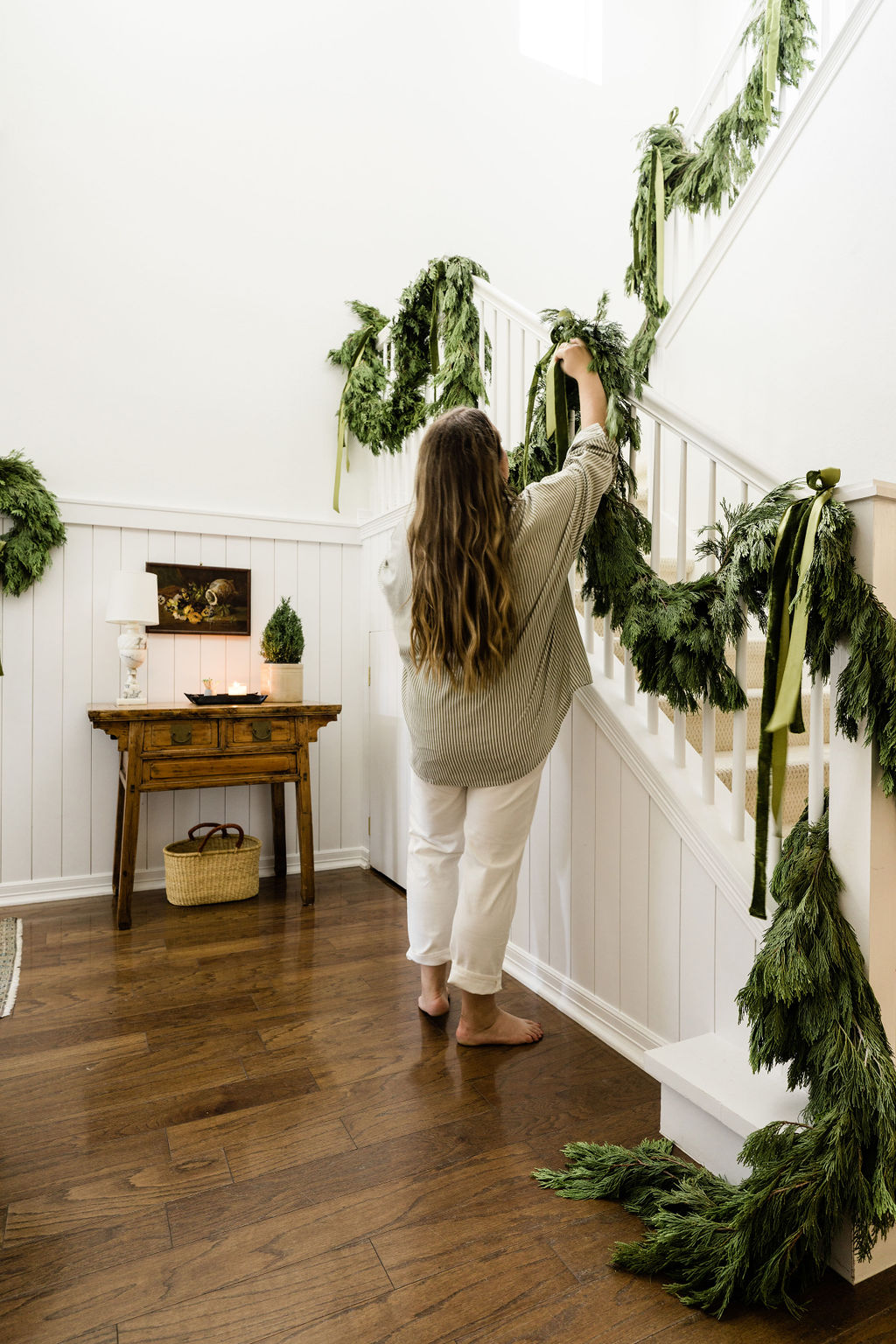 fresh cypress garland garnished with green ribbons decorating the entryway for Christmas
