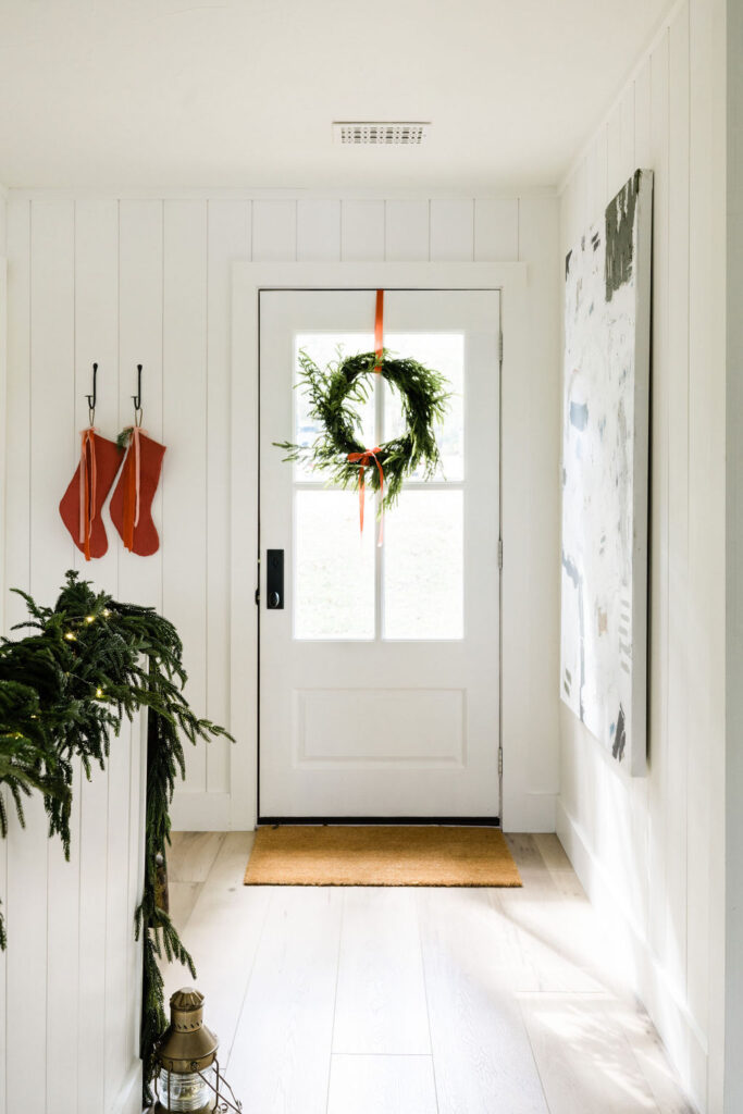 pine garland and red stocking holiday decor in the entryway