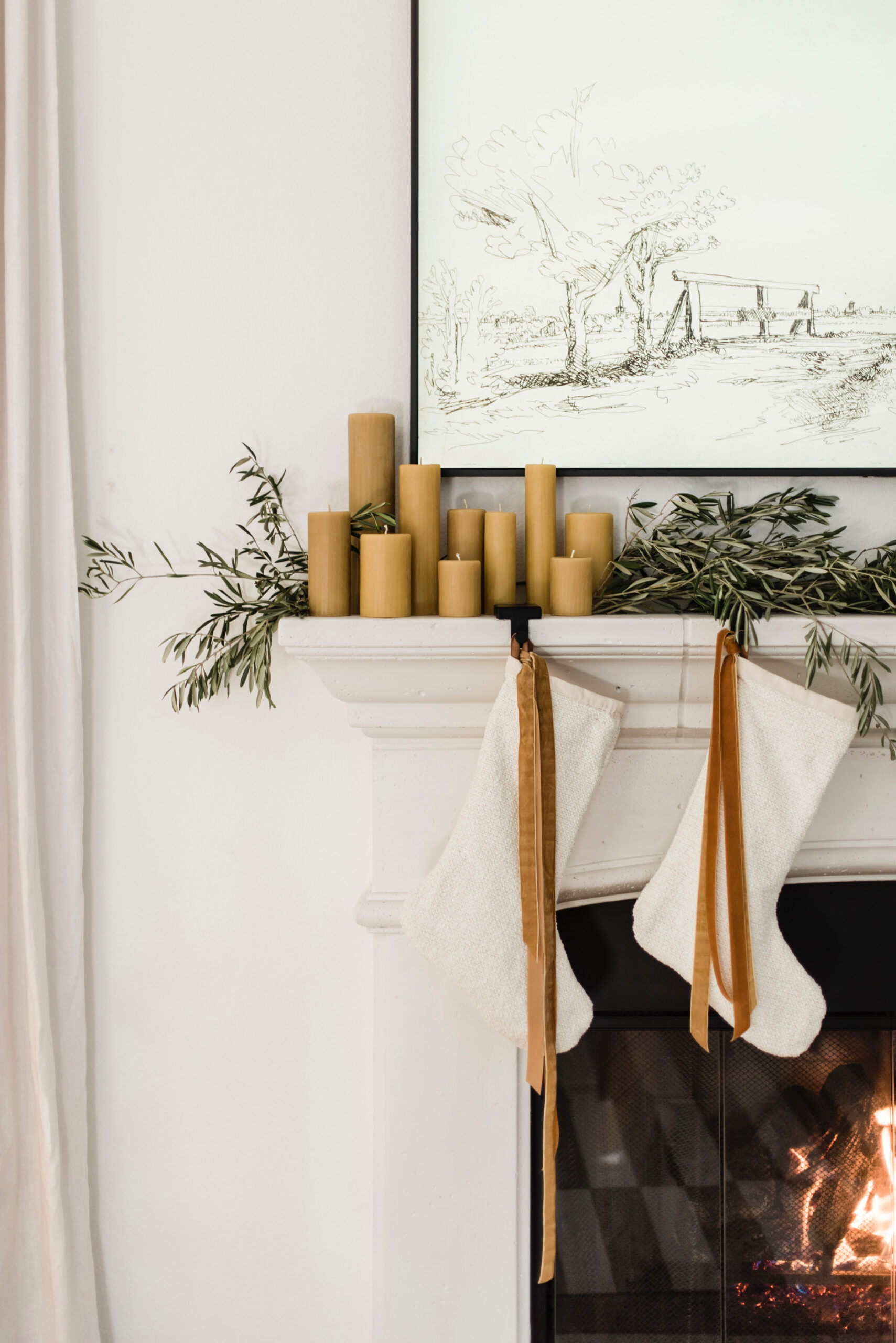 mantel styling with beeswax candles and velvet stockings olive leaf garland