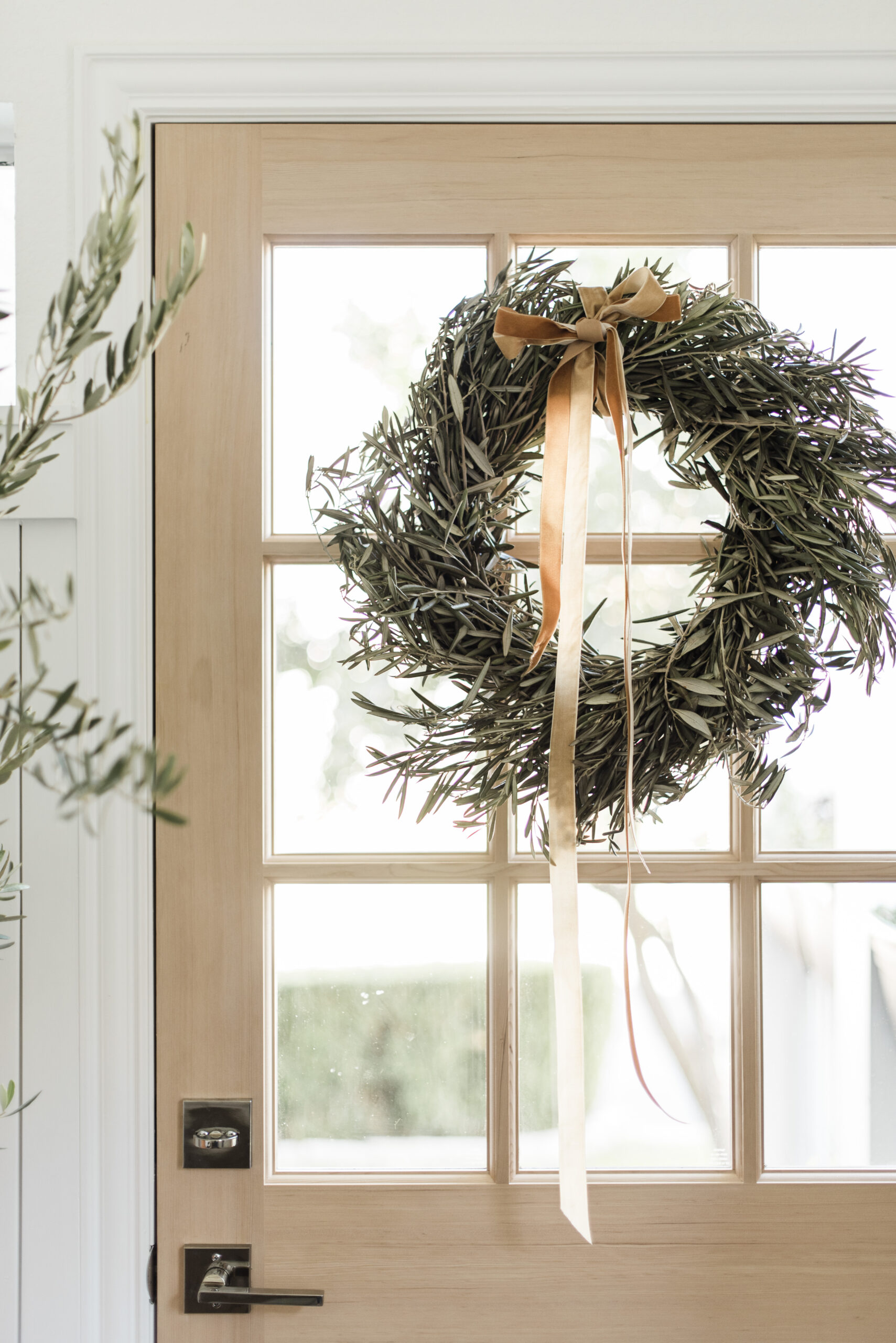 olive leaf wreath and copper velvet ribbon holiday decor on the front door