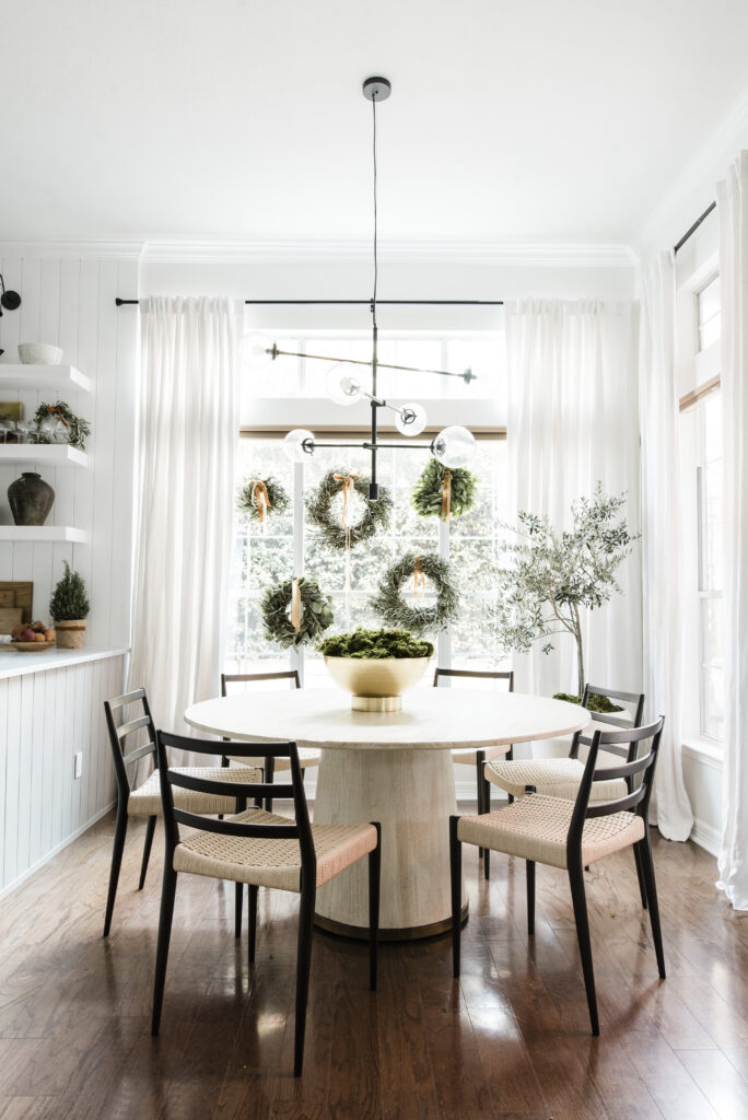 dining room holiday decor with five small wreaths clustered in the window