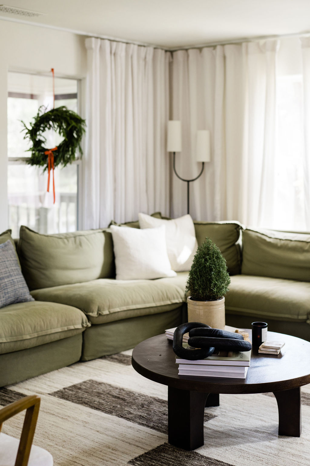 cozy green sectional seating with Christmas wreath styling