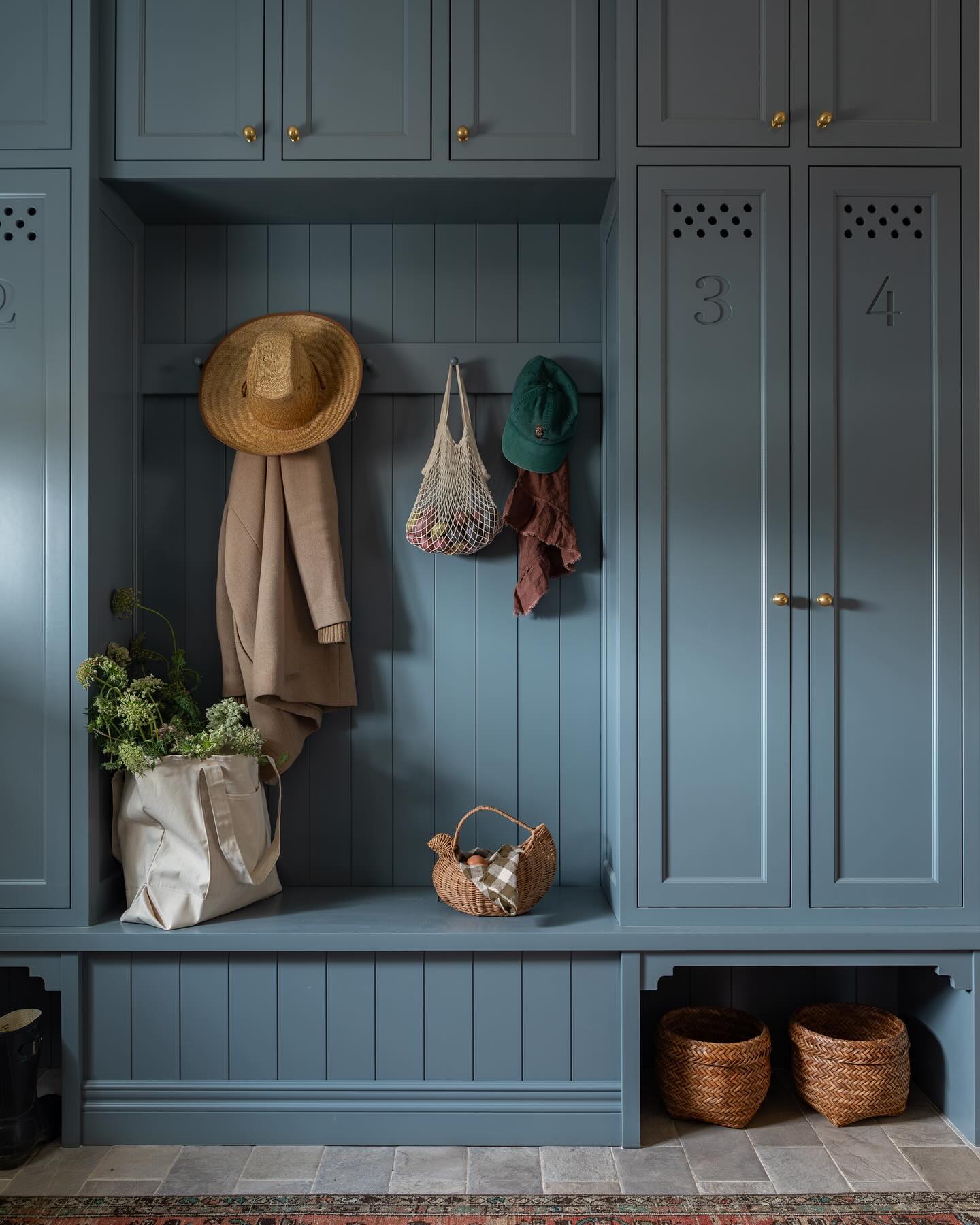 Locker style storage in a custom mudroom painted French blue