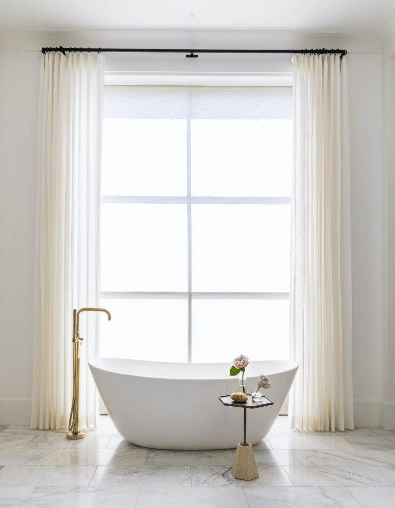 Freestanding soaking tub with brass hardware and finishes by Marie Flanigan Interiors