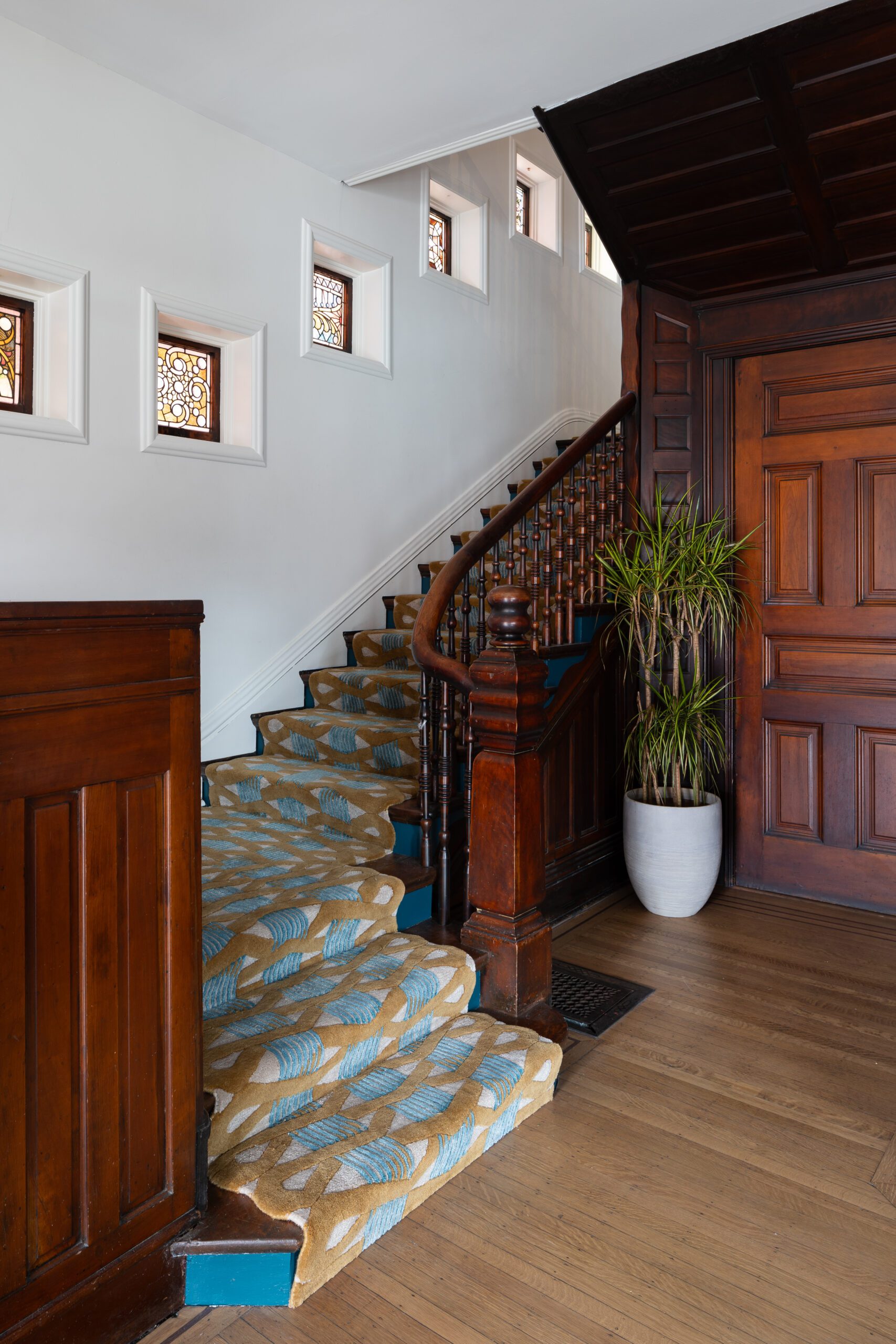 Carpeted Stairwell with Stain Glass Windows