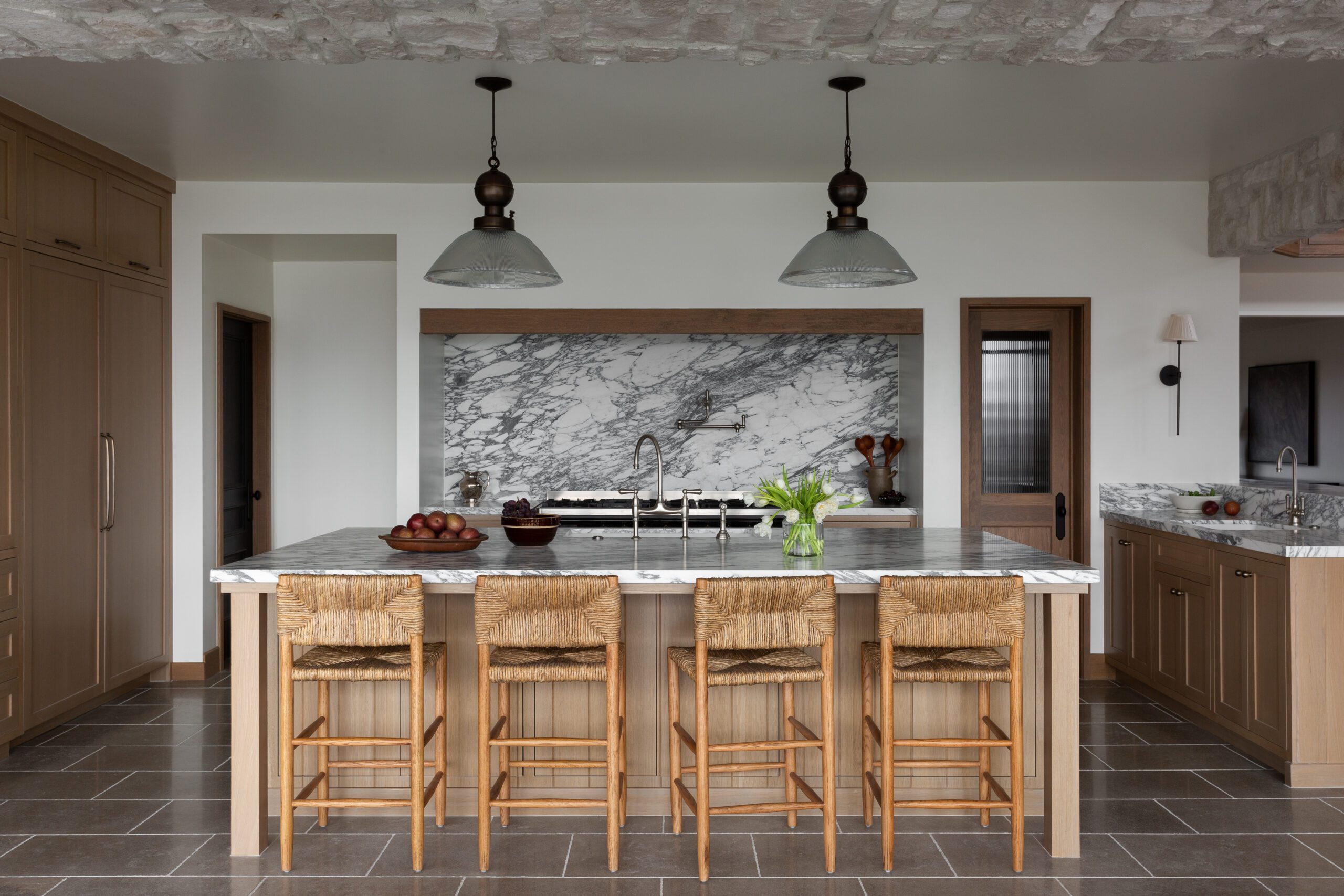 European villa inspired kitchen marble countertops woven chairs