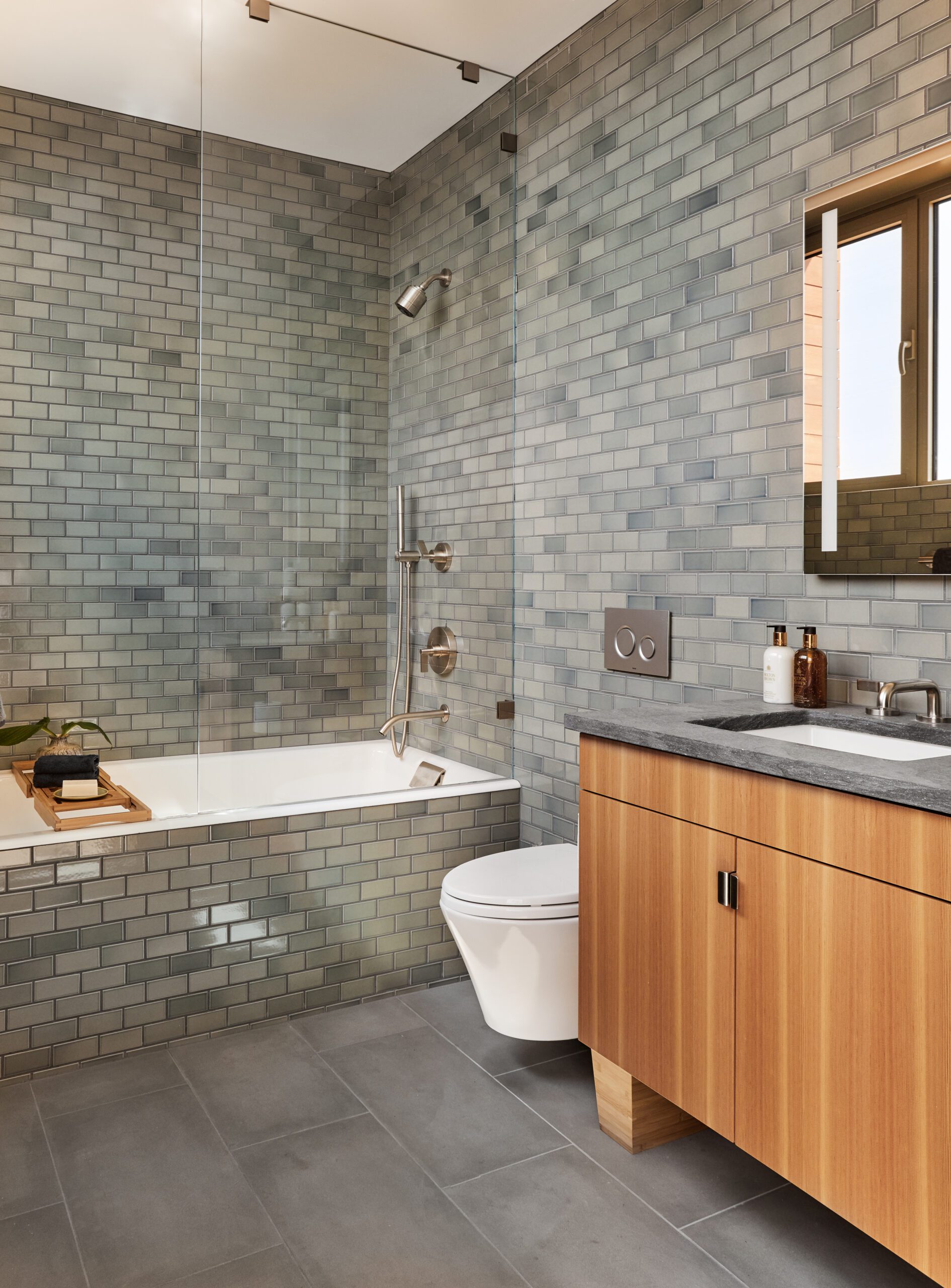 Midcentury modern home design bathroom with bathrub and gray wall tile