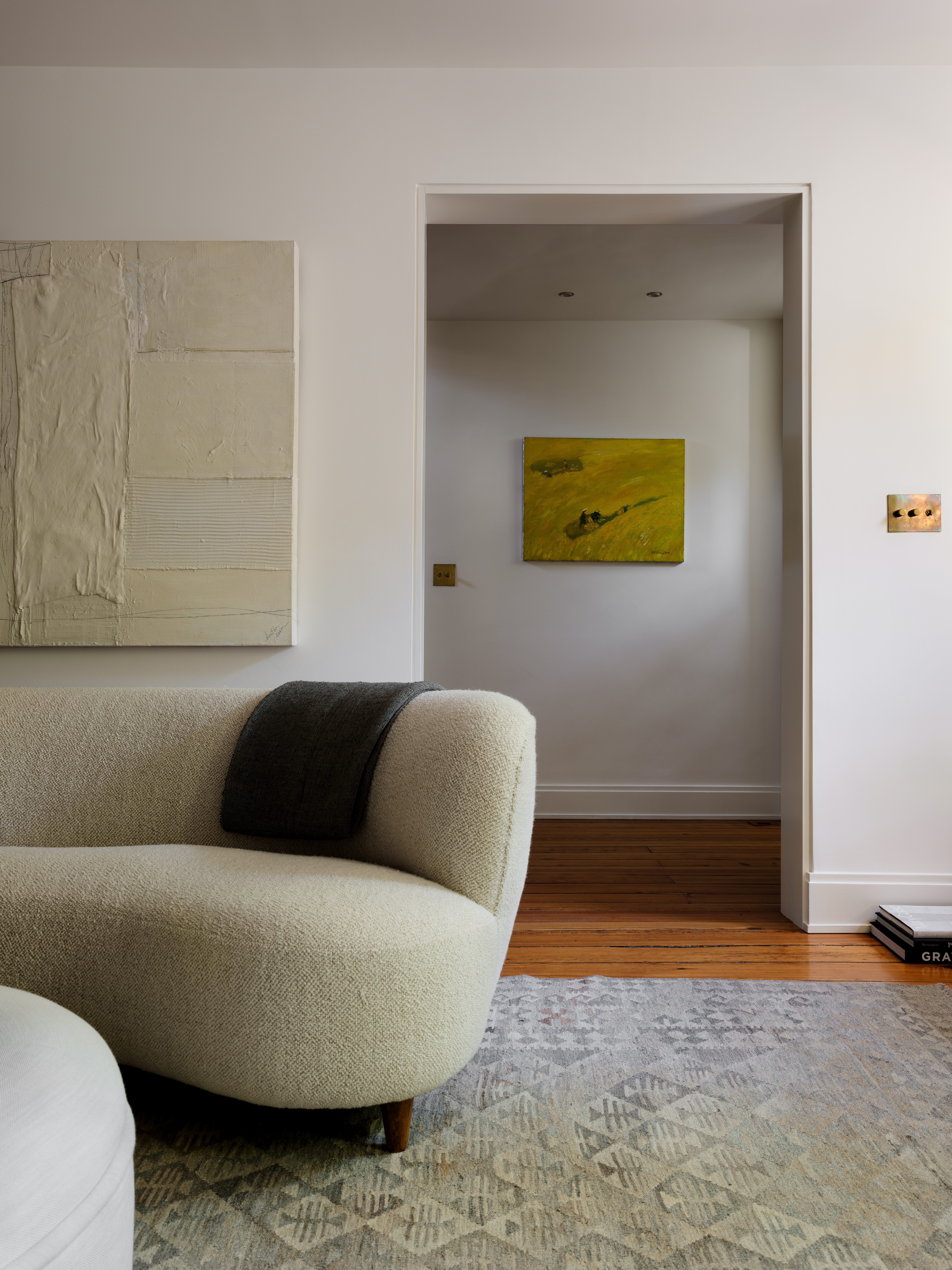 Modern living room curved sofa and vintage artwork vignette