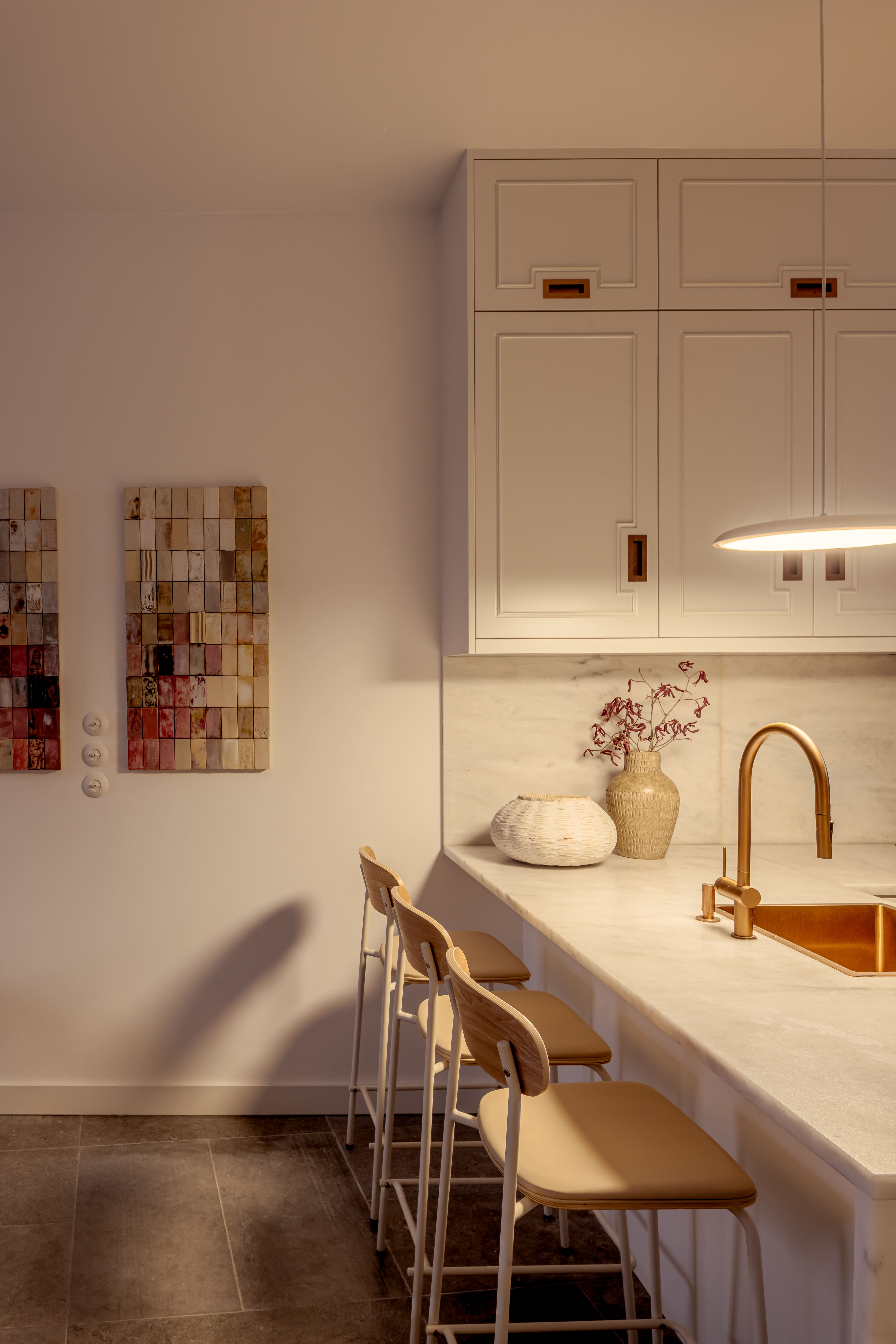 Artwork on wall in kitchen with marble countertops