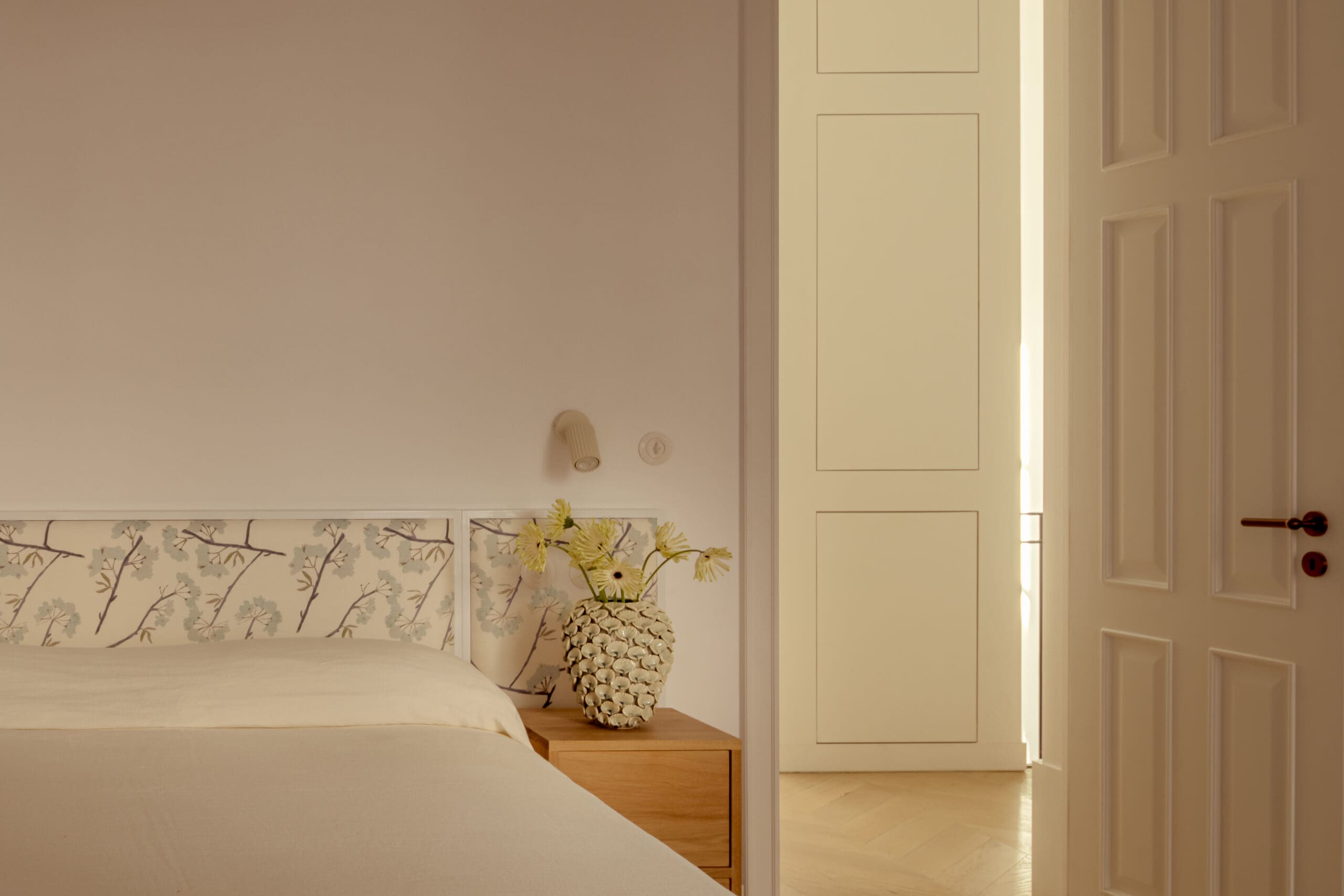 Bedroom with white wall and patterned headboard