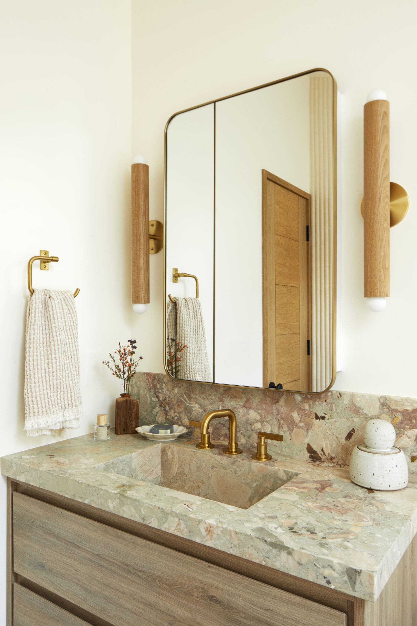 Powder bathroom with gold mirror