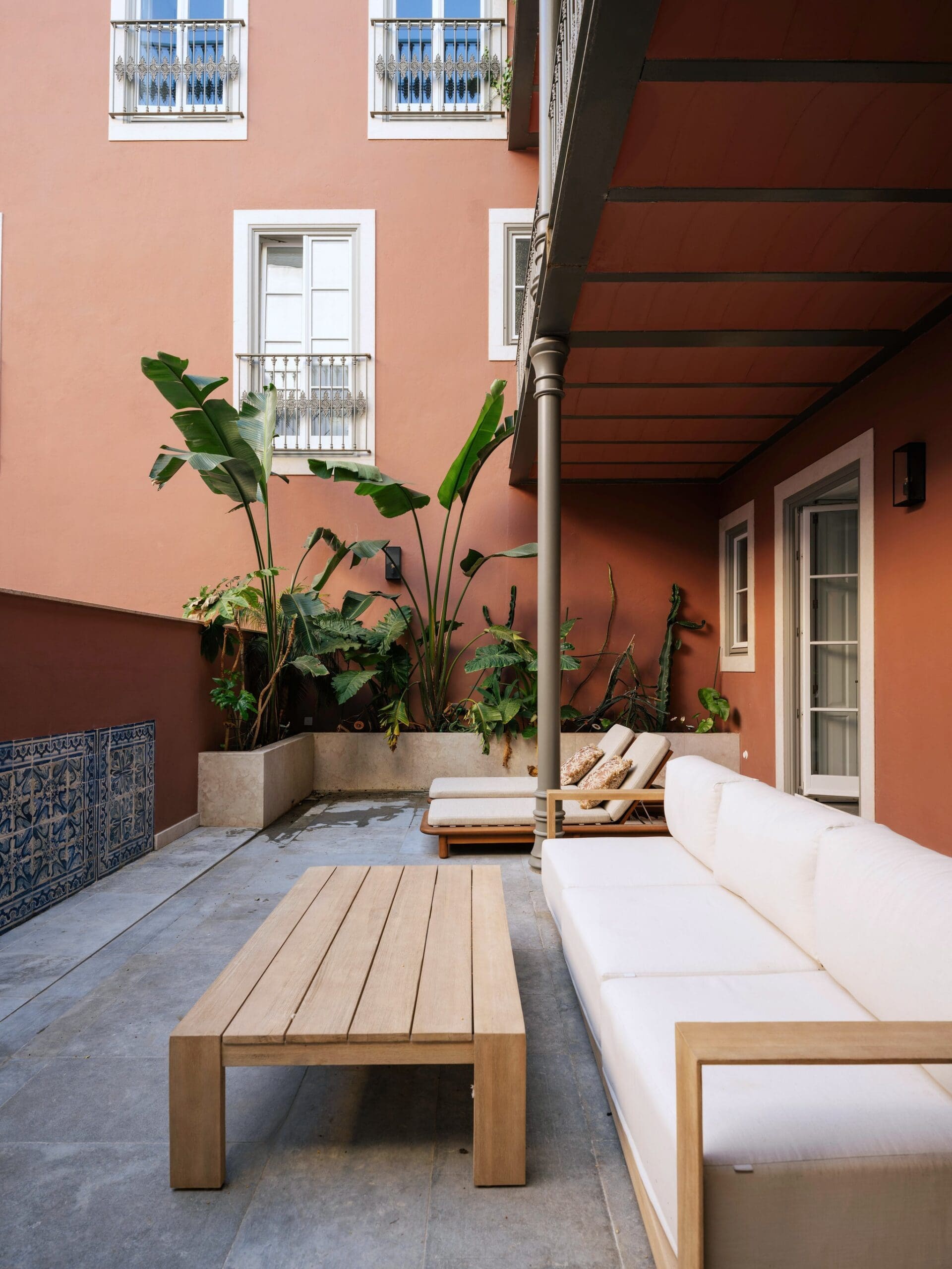 Red exterior of Lisbon apartment with greenery outside