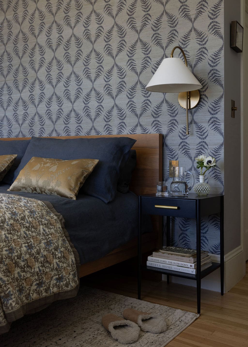 Bed frame and nightstands with wall sconce on wall