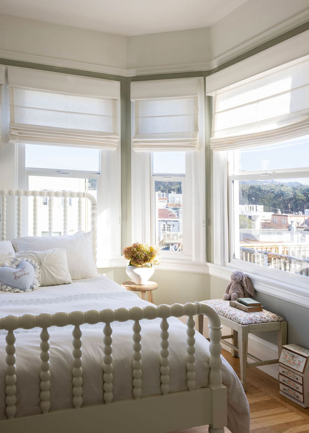 Bedroom with white bed frame and windows surrounding