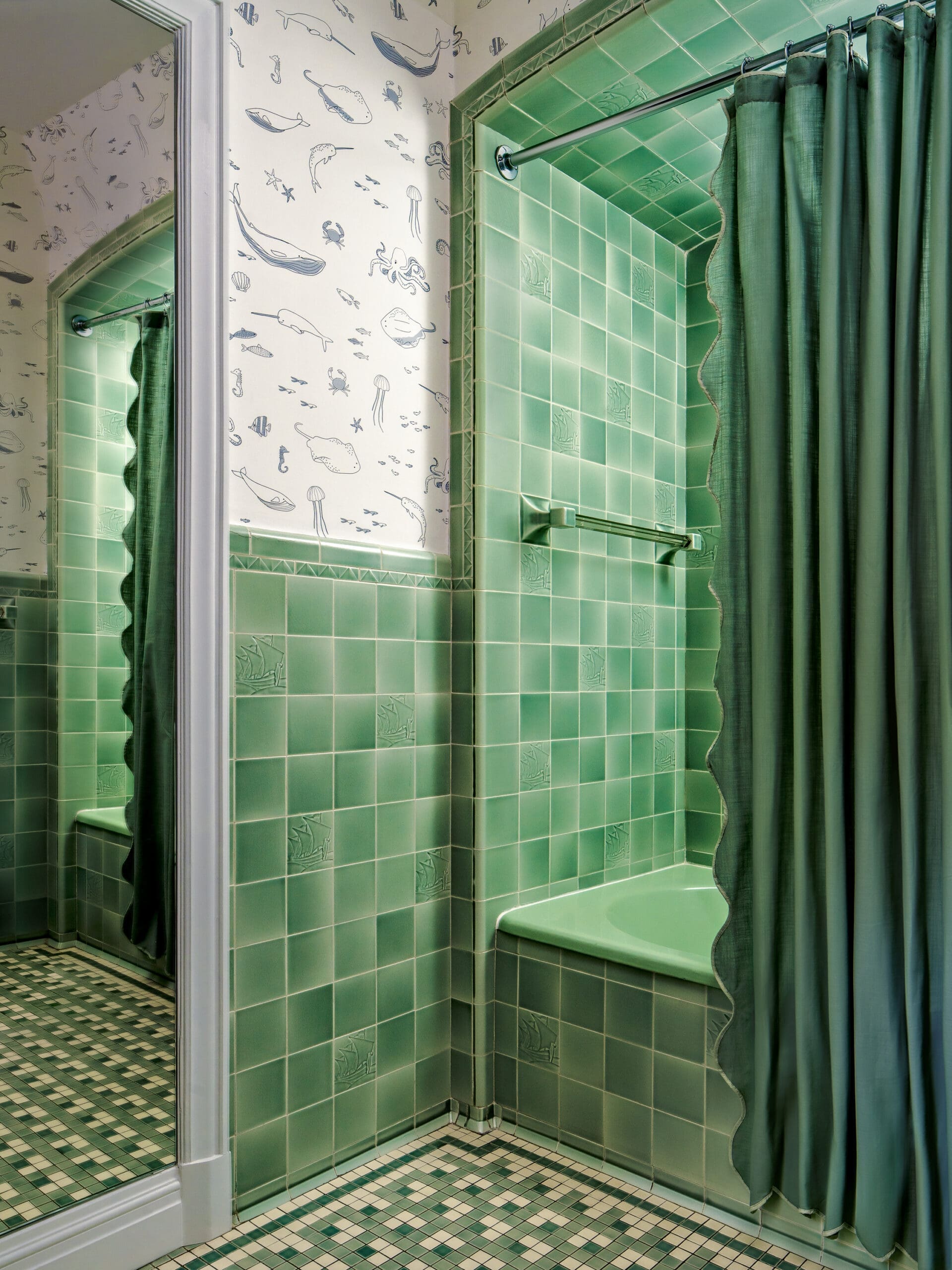 Retro bathroom with sea-life wallpaper, green tiled shower area, and a green shower curtain with a towel bar