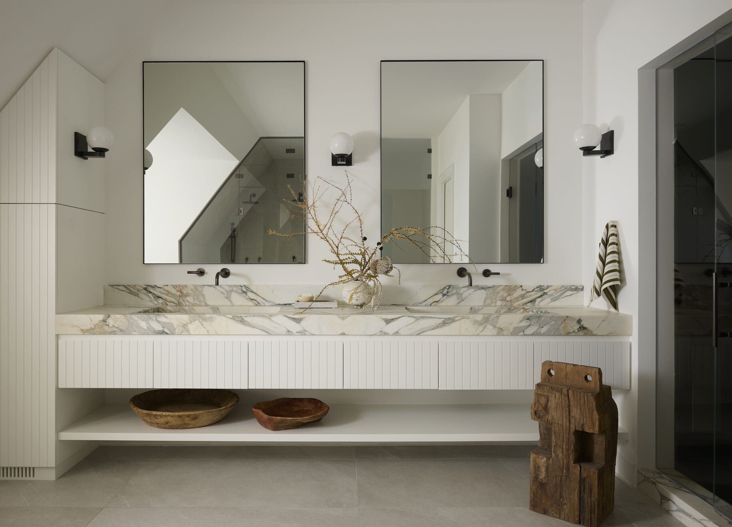 White bathroom with double vanity sink and mirrors