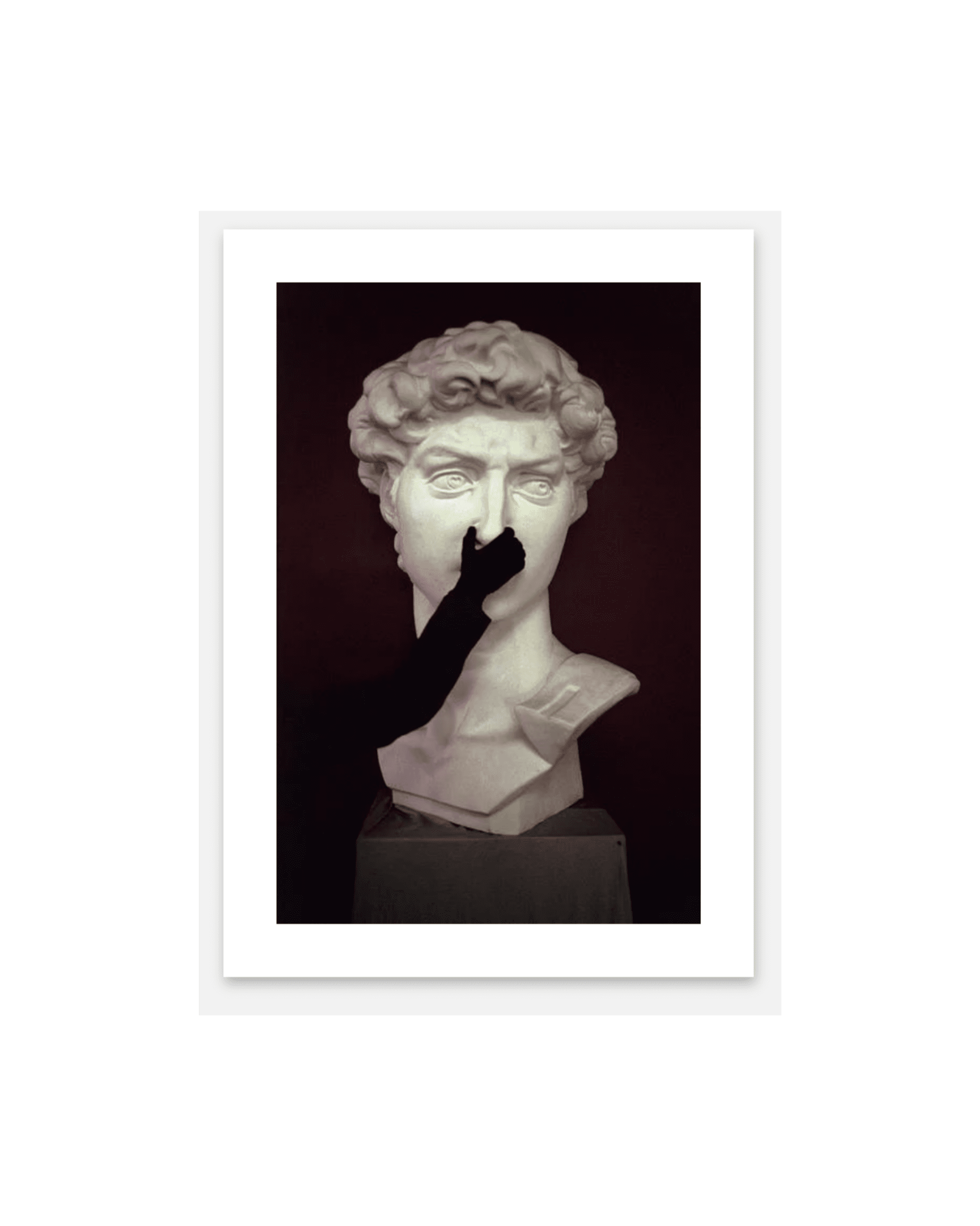 White marble bust of a man with curly hair against a dark maroon background, with a black silhouette hand covering the mouth area.