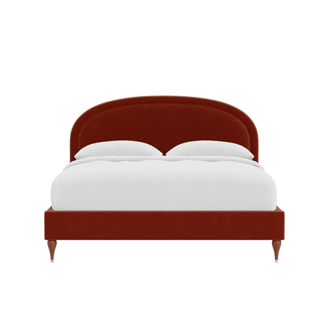 Red upholstered bed with a curved headboard and white duvet and pillows seen from the front, full bed on wooden legs