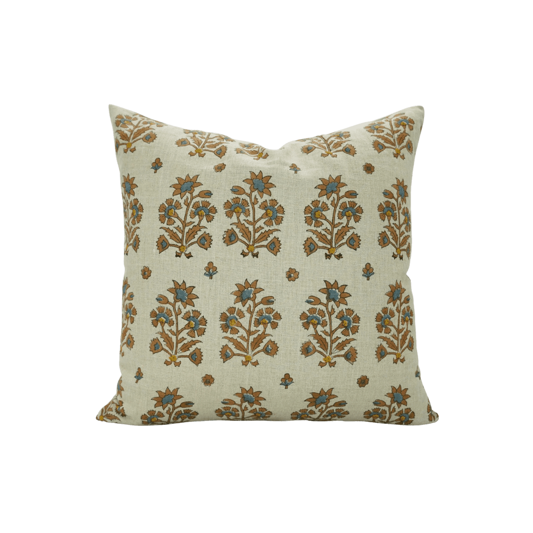 Beige throw pillow with blue and brown floral pattern across the fabric edge to edge, decorative cushion for a sofa.