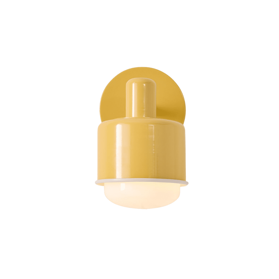 Yellow wall-mounted sconce with a cylindrical body and frosted glass diffuser at the bottom; round backplate visible behind the fixture.
