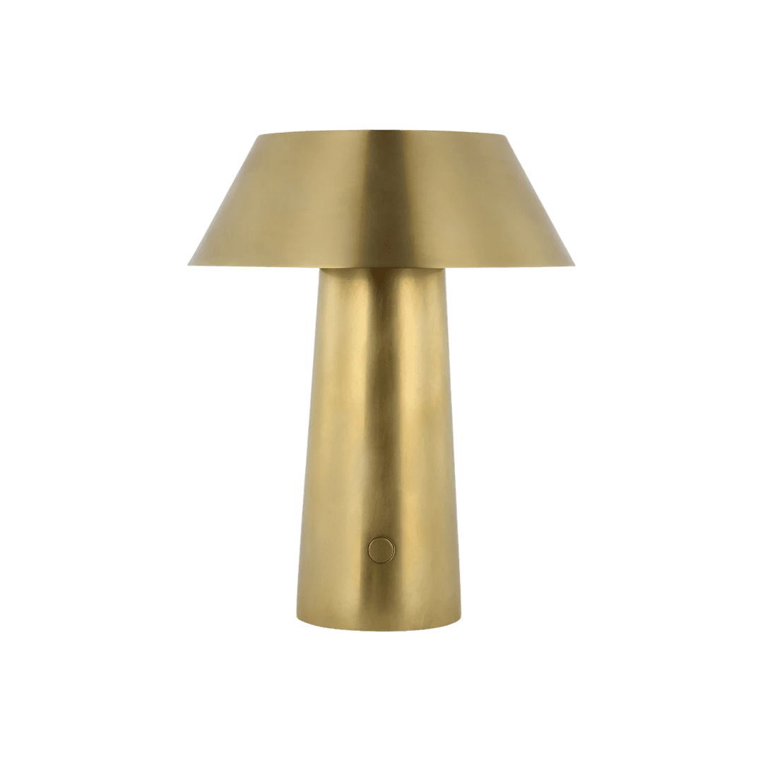 Gold metal table lamp with a wide, conical shade on a tapered base