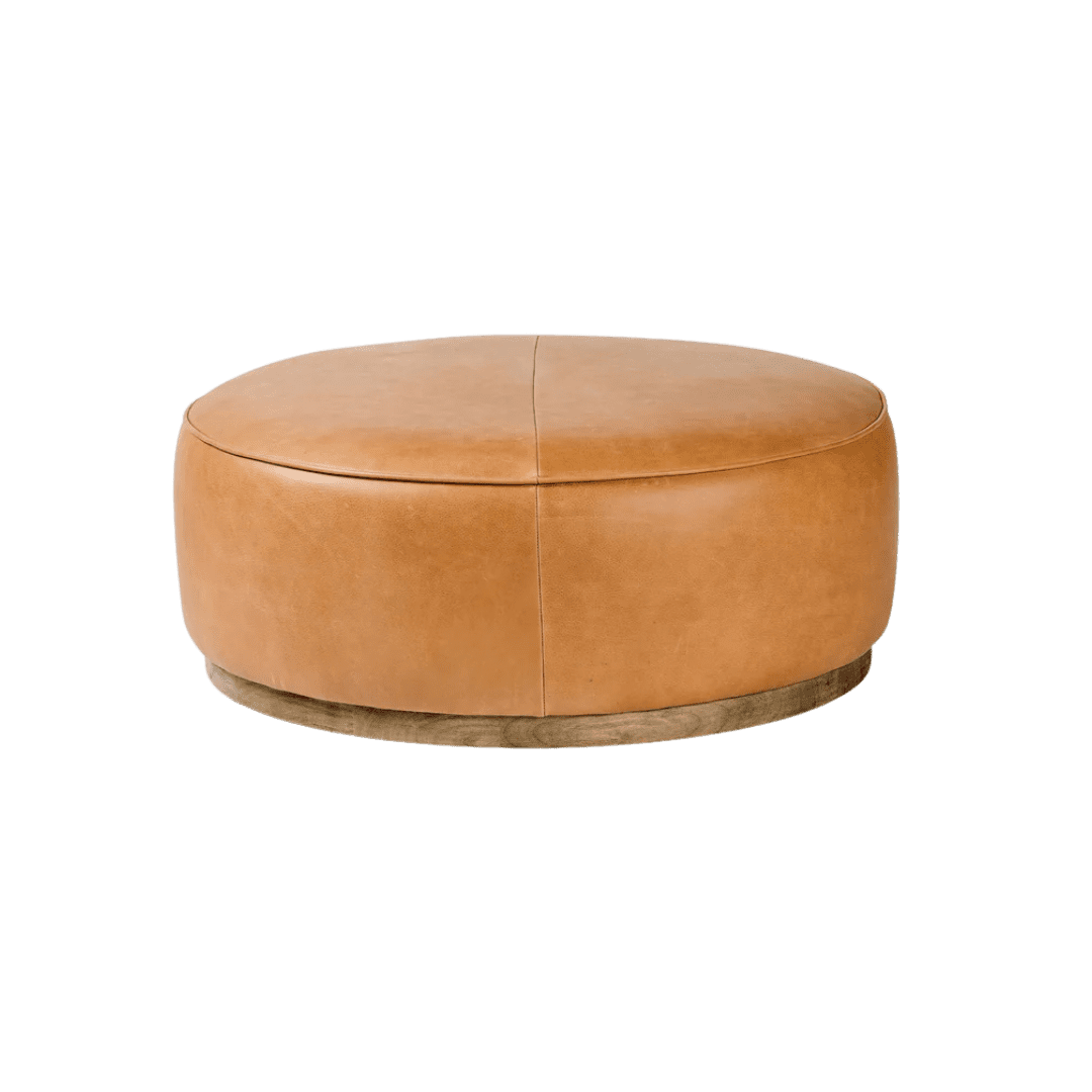 Round tan leather ottoman with a wooden base and seam detail