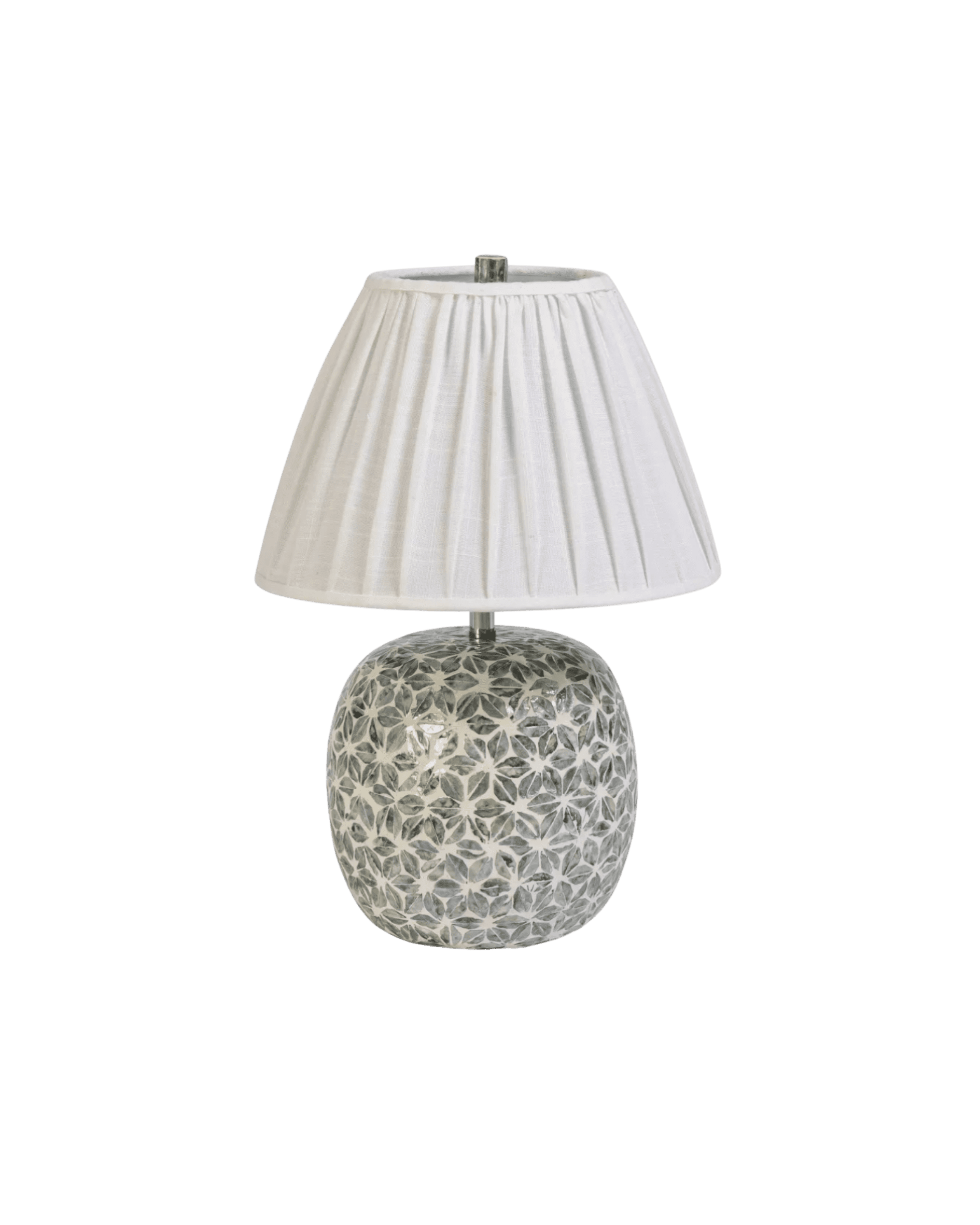 Table lamp with a white pleated lampshade and a patterned ceramic base against a black background.