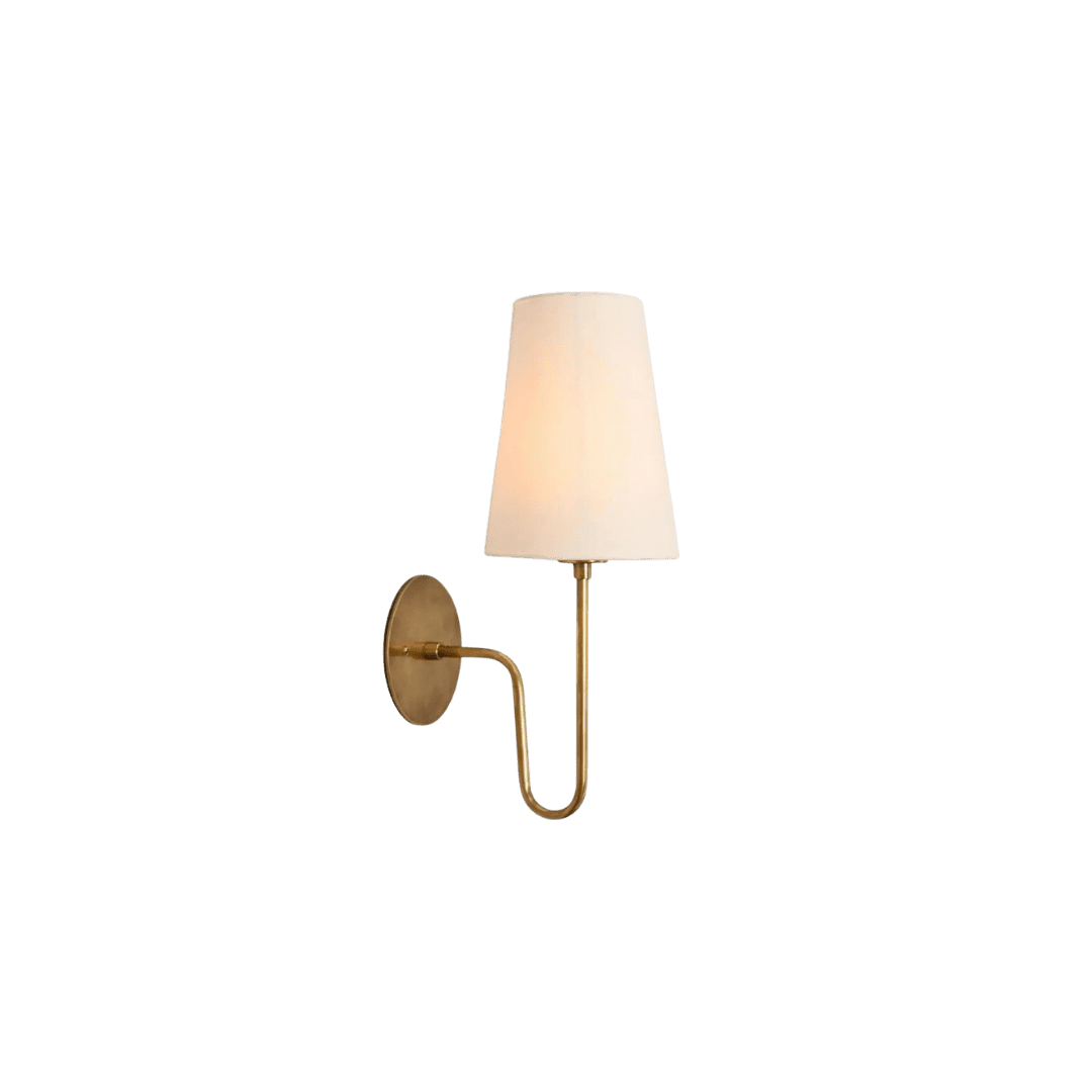 Brass wall-mounted sconce with a curved arm and a white fabric shade