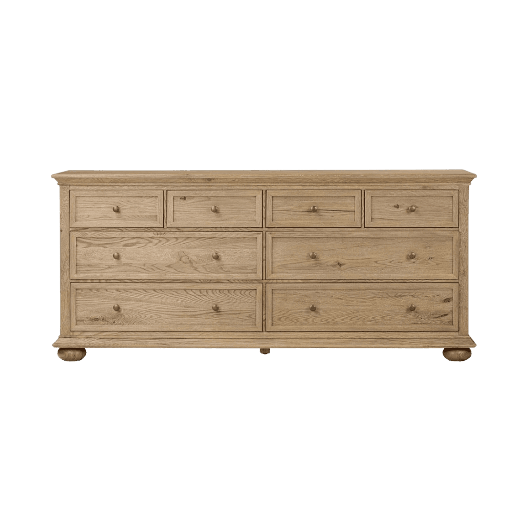 Oak wood dresser with eight drawers and round knobs, standing on rounded feet.
