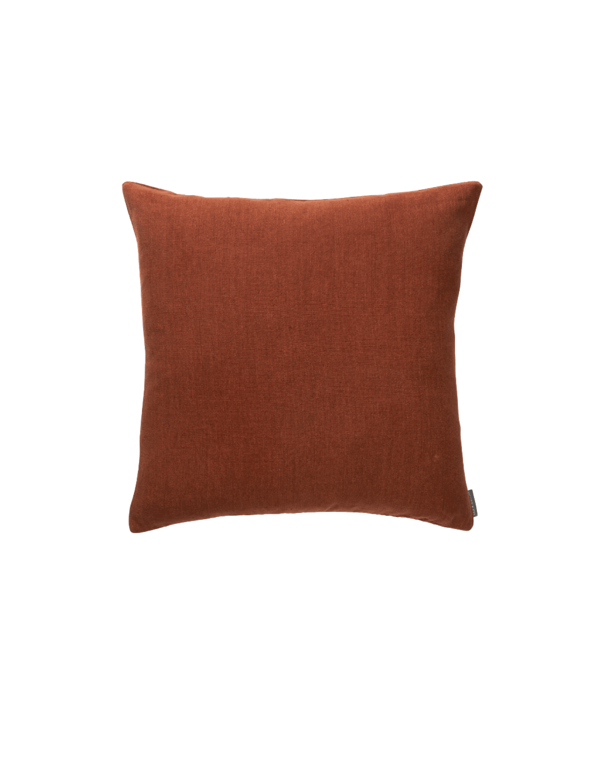 Rust-colored fabric throw pillow against a black background, showing the top edge and soft texture