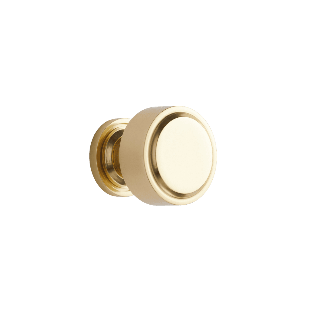 Polished brass door knob with a round shape and side mounting plate on a green background.