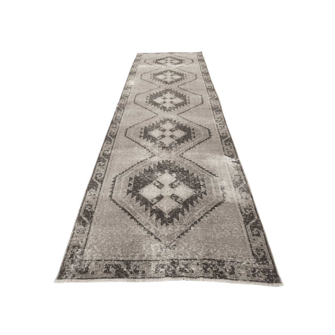 Long beige rug runner with repeating diamond motifs and a patterned border to emphasize hallway decor.