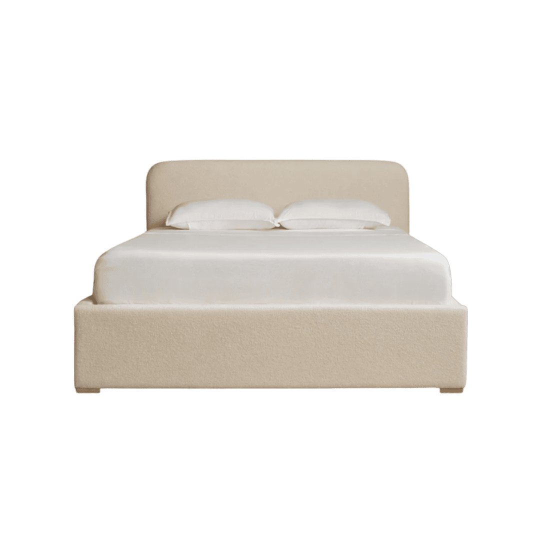 Beige upholstered platform bed with white sheets and two pillows against a green background.