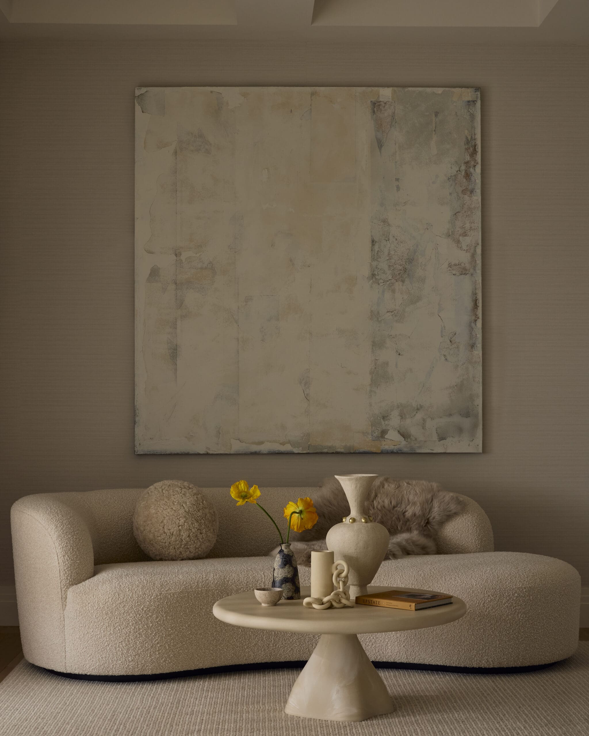Curved sofa with circular pillow and pedestal table